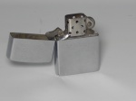 Isqueiro ZIPPO, metal prateado, cinzelado com o nome Sidney. Necessitando de revisão. 6 x 4cm.