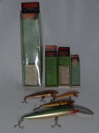 Quatro iscas com anzol para pesca em metal esmaltado. Todas na embalagem original. Apresentam marcas de uso. Comp. maior 23 cm, Comp. menor 9cm.