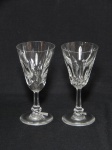 BACCARAT - Par de cálices para vinho do porto em cristal francês, haste facetada, bojo com lapidação geométrica em losangos. Apresentam bicados na borda. Alt. 11cm.