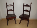 Par de cadeiras em madeira brasileira, pernas em X, barras laterais do encosto torneados terminando em bilros, assento de madeira (pequenos defeitos). Alt. total 110cm.