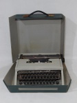 Máquina de escrever em metal e baquelite, manufatura OLIVETTI, modelo DORA, acondicionado em maleta, no estado. Necessita regulagem. 9 x 32 x 34cm.