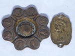 Duas peças em bronze: a) Cinzeiro português moldado com figuras típicas e nomes de localidades. Diam. 18cm b) Placa representando figura de soldado, assinatura não identificada, datação "1914 - 1916". 13 x 8cm.