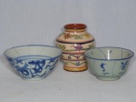 Três peças em cerâmica vitrificada: a) Bowl chinês, fundo cinza, decoração diversa em azul, assinado com selo ao fundo. Quebrado e colado. 7 x 14cm. b) Bowl cinza com decoração em azul claro. 5,5 x 12cm. c) Vasinho pintado à mão com flores e volutas. Alt. 11cm.