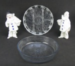 a) Par de castiçais em porcelana policromada, representando "Arlequins". No estado. Alts. 22,5 e 22 cm.b) Duas peças em cristal translúcido, sendo saladeira lapidada com flores e folhas e petisqueira com quatro divisórias lapidadas em sulcos. Saladeira com pequenos bicados na borda. Meds. 6x26 e 3x25,5 cm.