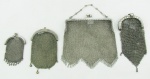 Quatro bolsas em malha de prata contrastada, sendo 1 para toilette e 3 para níquéis de diversos modelos e procedências. Pequenas perdas. Med. maior e menor 10x12 e 7x5 cm. Peso 165 g.