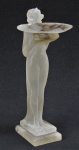 Despojador art-deco em ônix, na forma de concha, sustentada por figura feminina. Apresenta pequeno bicado na borda da concha. Alt. 18 cm.