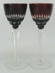 Par de taças de coleção de pé alto, em cristal na tonalidade translúcida e rubi. Lapidações em sulcos. Hastes sextavadas. Alt. 22 cm.