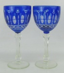 Par de taças de coleção em cristal europeu, na tonalidade doublet azul e translúcida. Lapidadas em olivas, dedão e sulcos bisotados. Hastes sextavadas. Alt. 20 cm.