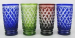Quatro copos em cristal de diversas cores. Lapidações em sulcos bisotados e tijolinho. Um apresenta bicado na borda. Alt. 13 cm.