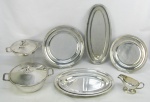 Baixela em metal espessurado a prata, com marca da manufatura Wolff, decorada com trabalhos em gregos, composto de sopeira, terrina com tampa, molheira, 3 bandejas ovais e 2 circulares. Sopeira com pequena mossa na base. Sopeira 16x34,5x27 cm.
