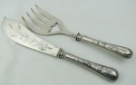 Christofle - Dois talheres franceses para serviço de mesa monogramados e com marca da manufatura em metal espessurado a prata, sendo garfo e espátula com trabalhos em baixo relevo, tendo a espátula desenho de um peixe entre folhagens. Comp. 25 e 28,5 cm.