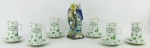 a) Seis xícaras para café em porcelana japonesa, decorada com pintura de trevos. Frisos em dourado. Alt. xícara 10cm. b) grupo escultórico em porcelana policromada, representando "Casal de periquitos" sobre troncos. Alt. 19,5cm.