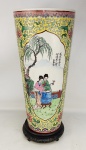 Bengaleiro no formato de cone, em porcelana oriental, profusamente decorado com pintura de cenas do cotidiano em reserva e arabescos, flores e folhagens. Detalhes esmaltados. Apresenta em cada cena inscrição e assinatura. Marca da manufatura na base. Acompanha peanha em madeira entalhada. Alt. total com peanha 49,5 cm.