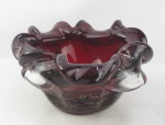 Cinzeiro em murano na cor vinho, trabalhado com gomos em relevo e decorado internamente com pó de ouro. Med. 12,5x22,5x22,5cm.
