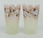 Par de copos de coleção em vidro italiano, decorado com pintura floral em policromia. Um apresenta minúsculo bicado na borda. Alt. 10 cm.
