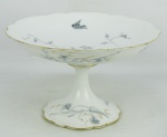 Centro de mesa de pé, em porcelana francesa na cor leitosa, possivelmente Limoges. Decorado com folhagens, flores, pássaros e borboletas em tons de cinza. Detalhes em dourado, com desgastes. Med. 13,5x22,5cm.