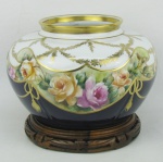 Cachepot em porcelana policromada e decorada com pintura floral e belos trabalhos em dourado com guirlandas, laços de fita e frisos. Med. 14,5x20,5 cm.