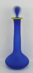 Garrafa em vidro, anos 50, no tom azul. Borda decorada com faixa amarela. Alt. 32cm.