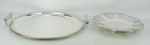 a) Bandeja circular com alça em metal espessurado a prata, decorada com trabalhos de folhas, flores, volutas e geométricos. Diam. 44,5cm.b) Fruteira em metal espessurado a prata, decorada com trabalhos vazados na aba. Med. 5x31cm.