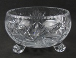 Centro de mesa em cristal europeu, decorado com lapidações de rosetas, sulco e frisos em relevo. Pés na forma de volutas. Med. 14,5x23,5cm.