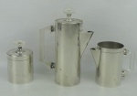 Três peças para serviço de chá e café em metal espessurado a prata, com marca da manufatura  Bristol na base, sendo bule, leiteira e açucareiro. Pega das tampas e alças em acrílico. Alt. maior e menor 18 e 10cm.