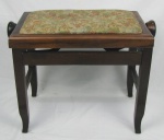 Banco para piano em madeira entalhada, com regulagem de altura. Pernas de seção quadrada. Assento estofado e forrado com tecido floral. Pequenas marcas de uso. Med. 47x61x34cm.