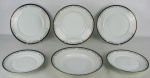 Trinta e sete pratos em porcelana alemã, com marca da manufatura Rosenthal no verso, com borda no tom azul cobalto e aba decorada com guirlandas de folhas em dourado, sendo 18 pratos rasos, 6 fundos e 13 para sobremesa. Um prato raso com lascado na borda. Diam. maior e menor 25,5 e 21,5cm.