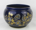 Belo cachepot em faiança francesa, no tom azul cobalto, com marca da manufatura Sarreguemines a crivo na base, decorado com flores e folhagens na cor prata e dourado e em relevo. Med. 18x25cm.