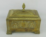 Caixa monogramada em metal dourado, ricamente decorada com trabalhos de flores, folhas, folhas, guirlandas e sulcos. Pegador da tampa na forma da pinha. Med. 15x17,5x13 cm.