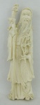 Escultura em marfim oriental, representando "Sábio". Parte superior do cajado, apresenta colagem e falta um pedaço. Alt. 15,5 cm.