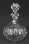 Licoreiro bojudo em cristal translúcido, decorado com lapidações dedão e olivas. Parte interna da tampa com batidinhas e borda do gargalo com bicado. Alt. 22 cm.