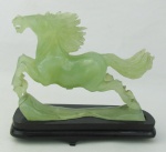 Escultura em jade representando "Cavalo". Base em madeira entalhada, faltando um pé da base. Med. total 14,5x16x5 cm.