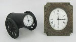Dois relógios de mesa suíços, sendo um da manufatura Bucherer Inhof, com moldura em bronze trabalhado com flores, e o outro da manufatura Jaguar, com caixa em bronze na forma de canhão. Maquinas necessitam reparos. Med. 9x7,5 e 7x7x11cm.