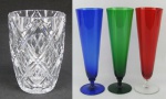 a) Vaso em cristal translúcido, lapidado com sulcos, dedão e na base estrela de 24 pontos. Alt. 19cm.b) Três tulipas coloridas em demi cristal, sendo uma vermelha, uma verde e uma azul. Alt. 23cm.