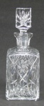 Licoreiro de seção quadrada em cristal translúcido, com lapidações dedão, sulcos  e rosetas. Tampa numerada. Alt. 25,5cm.