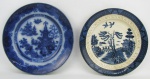 a) Belo e antigo prato de coleção do Séc. XIX, em porcelana azul borrão. Decorado ao centro com paisagem lacustre. Aba com flores, folhagens e arabescos. Diam. 23,5cm. b) Antigo prato em faiança, decoração pombinhos no tom azul. Marca da manufatura no verso. Aba com discreto fio de cabelo. Diam. 22,5cm.