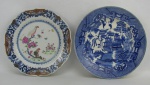 Dois pratos, sendo um em antiga porcelana policromada, decorado com pintura de flores, pássaro sobre galho e borboletas, com detalhes esmaltados. Borda em ondulações. Apresenta pequenos bicados na borda, e o outro em porcelana com decoração pombinhos na cor azul. Diamts. 22,5 e 23,5cm.