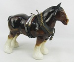 Estatueta em porcelana policromada representando "Cavalo". Adereços em metal e tecido. Adereços com desgastes causados pelo tempo. Med. 22x27x9cm.
