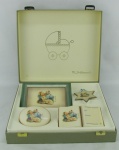 Conjunto com 4 peças decorativas para bebê em porcelana alemã, com marca da manufatura Goebel, decoradas com cenas de bebê no berço em policromia. Na caixa. Med. maior e menor 18,5x13,5 e 9x8cm.