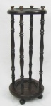 Bengaleiro em madeira entalhada, tendo na parte superior bilros com apliques de moedas, sobre quatro colunas torneadas, que se apoiam a uma base circular. Pés em bola. Pequenas marcas de uso. Borda superior com uma fissura. Alt. 70cm.