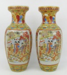 Par de vasos policromados em porcelana oriental, decorados com flores, folhas e em reserva cena de paisagem com figuras. Alt. 20cm.