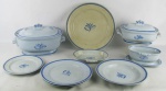 Aparelho de jantar em faiança sueca, com marca da manufatura Gefle Blatt-Band, com decoração de folhas e faixas no tom azul, composto de sopeira, 2 terrinas com tampa, prato para arroz, 2 molheiras, petisqueira, 23 pratos rasos, 11 fundos e 10 para sobremesa. Total de 51 peças. Com manchas causadas pelo tempo. Cinco pratos rasos com bicados nas bordas e um prato fundo e um para sobremesa com fio de cabelo na aba. Med. sopeira 17,5x31x20,5cm.