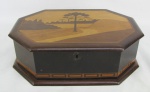 Porta jóias em madeira com detalhes em marqueterie, tendo sobre a tampa paisagem do Paraná. Parte interna com 4 divisórias, sobre fundo falso. Minúsculas marcas de uso e falta chave. Med. 10x32,5x22cm.