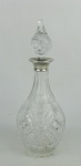 Licoreiro em cristal europeu translúcido, com lapidações de sulcos, dedão e tijolinho. Gargalo em prata inglesa contrastada. Parte interna com pequenos focos de mofo e parte interna do gargalo com pequenos trincados. Alt. 32cm.