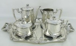 Serviço para chá e café em metal espessurado a prata, com marca da manufatura Fracalanza na base, decorados com gomos e laços de fita em relevo, composto de bandeja, 2bules, leiteira e açucareiro. Med. bandeja 51x33cm. Alt. bule maior 18cm.