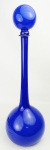 Garrafa de coleção, Art-deco, com gargalo alto, em vidro opalinado na cor azul e interior na cor leitosa. Tampa apresenta 2 batidas na parte de baixo. Alt. 53,5cm.