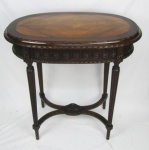 Mesa de apoio / apresentação, estilo francês Luis XVI, em madeira entalhada. Tampo ovalado.  Pernas torneadas e frisadas. Med. 79,5x81x50cm.
