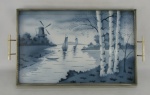 Bela bandeja de coleção em faiança européia decorada ao centro com pintura de paisagem com rio, barcos a vela e moinho, nos tons de azul degrade em policromia. Guarnições em metal. Pés em pata. Med. 4x49x27cm.