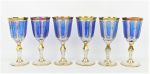 Seis belas e raras taças em cristal tcheco, no tom azul e translúcido, com lapidações de sulcos e facetados. Ricamente decoradas com detalhes em dourado. At. 17,5cm.