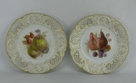 Par de belos pratos de coleção em porcelana alemã, com marca da manufatura KPM Berlim no verso, decorados com pintura de frutas em policromia. Abas com trabalhos vazados e ricos detalhes em dourado. Diamts. 22cm.